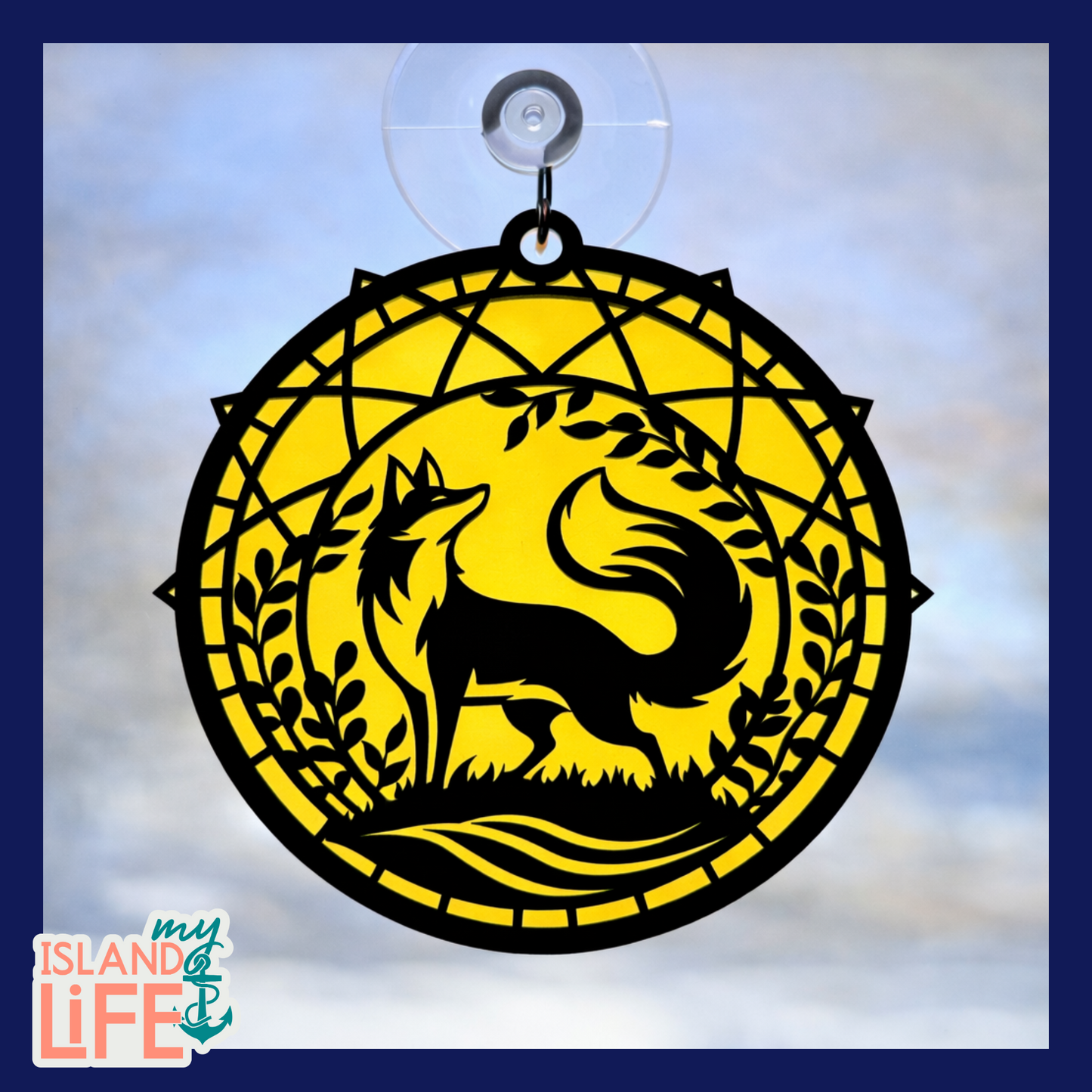 Decorative window hanging with a fox design on a yellow circle against a blue sky background.
