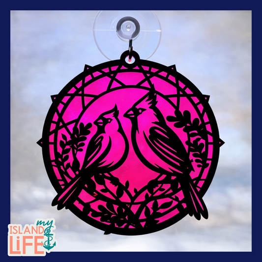 Decorative pink and black bird design with a suction cup on a light blue background.