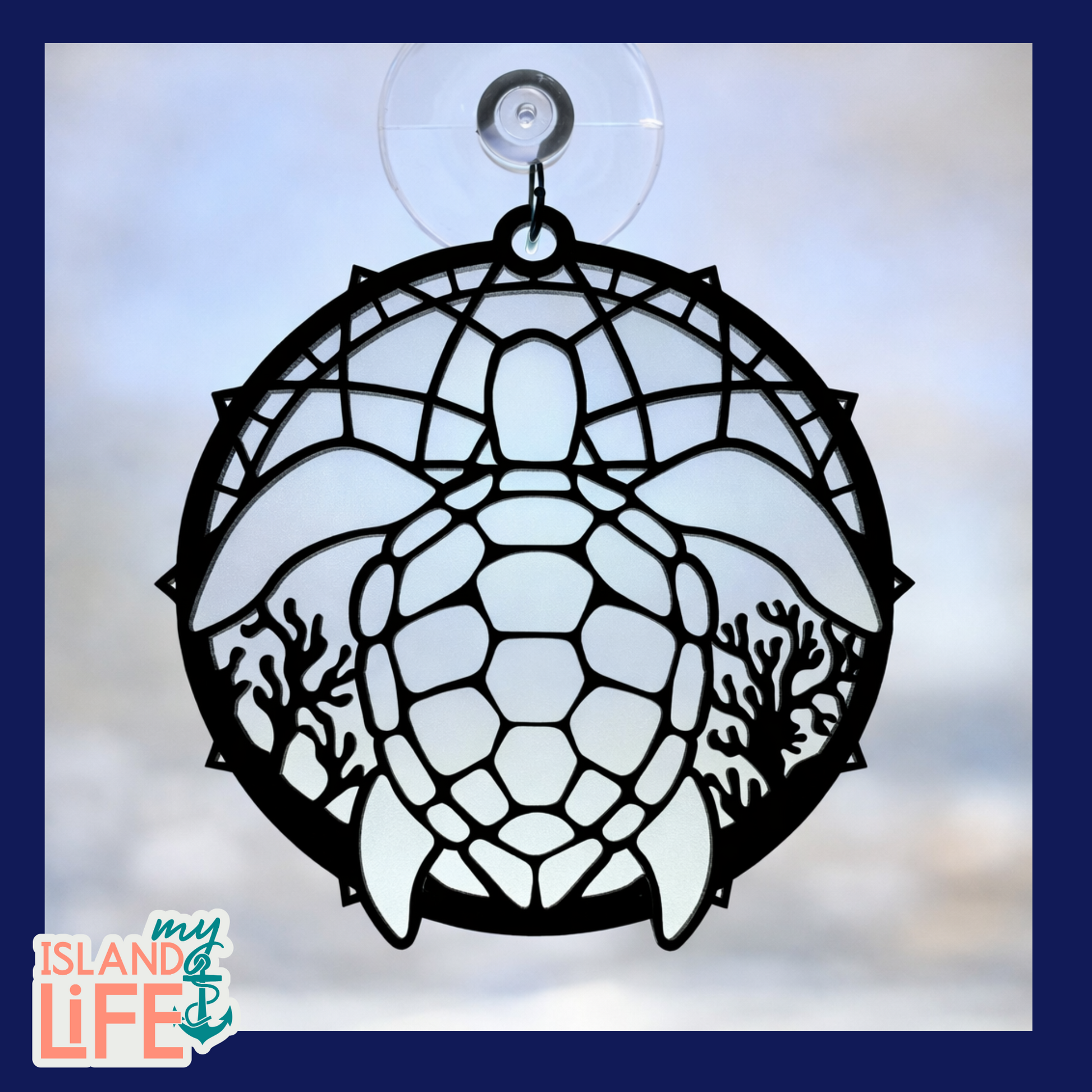 Decorative turtle-shaped window hanging with a suction cup on a blurred background.